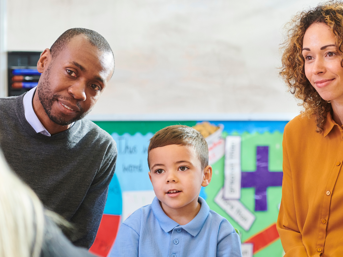Parents and a student meeting a teacher.
