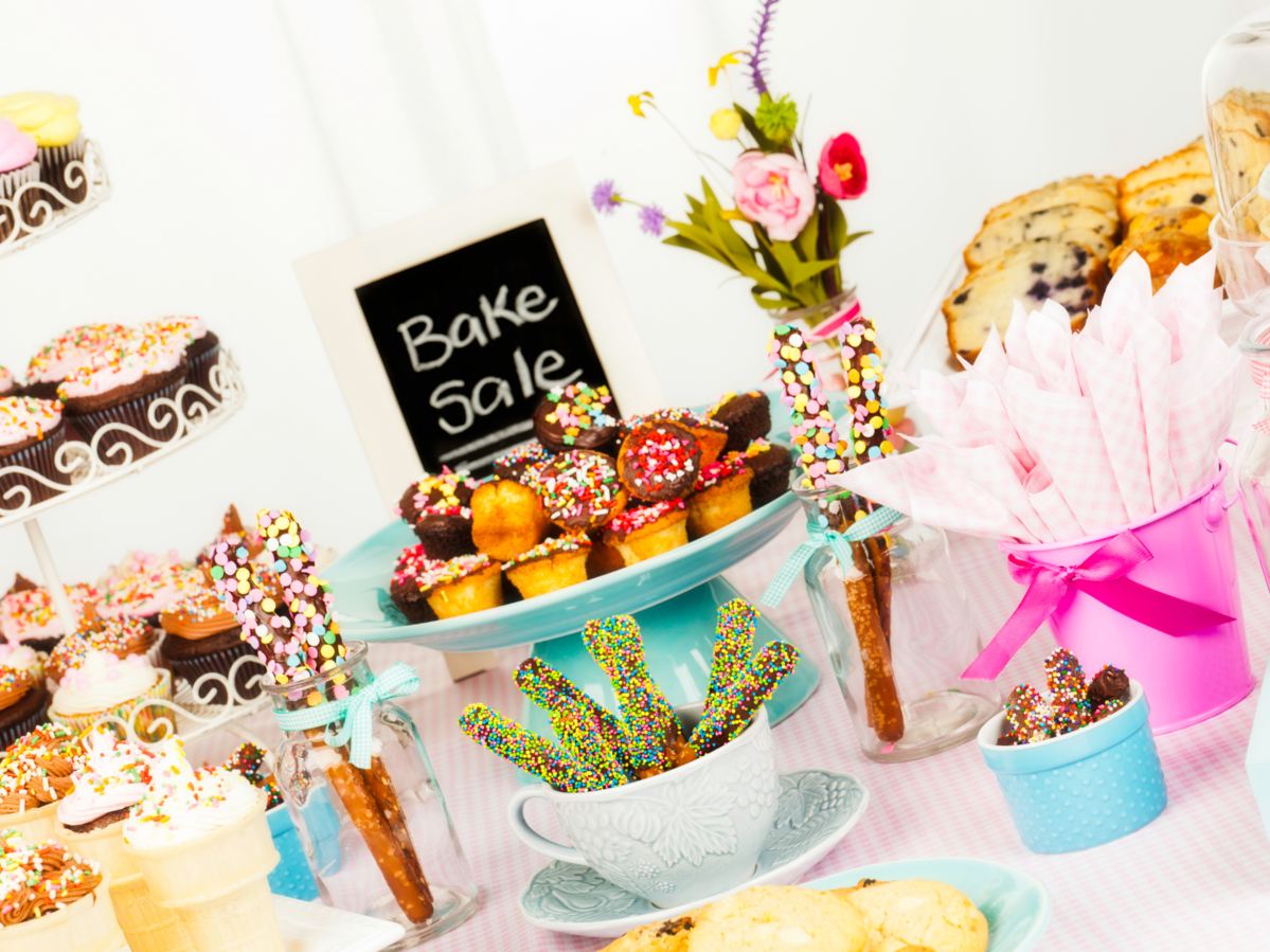 Bake sale items on a table with a sign.