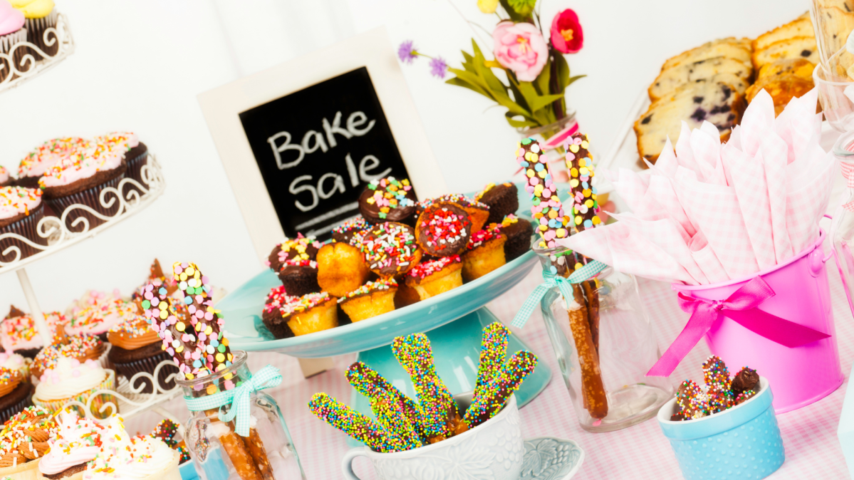 Bake sale items on a table with a sign.