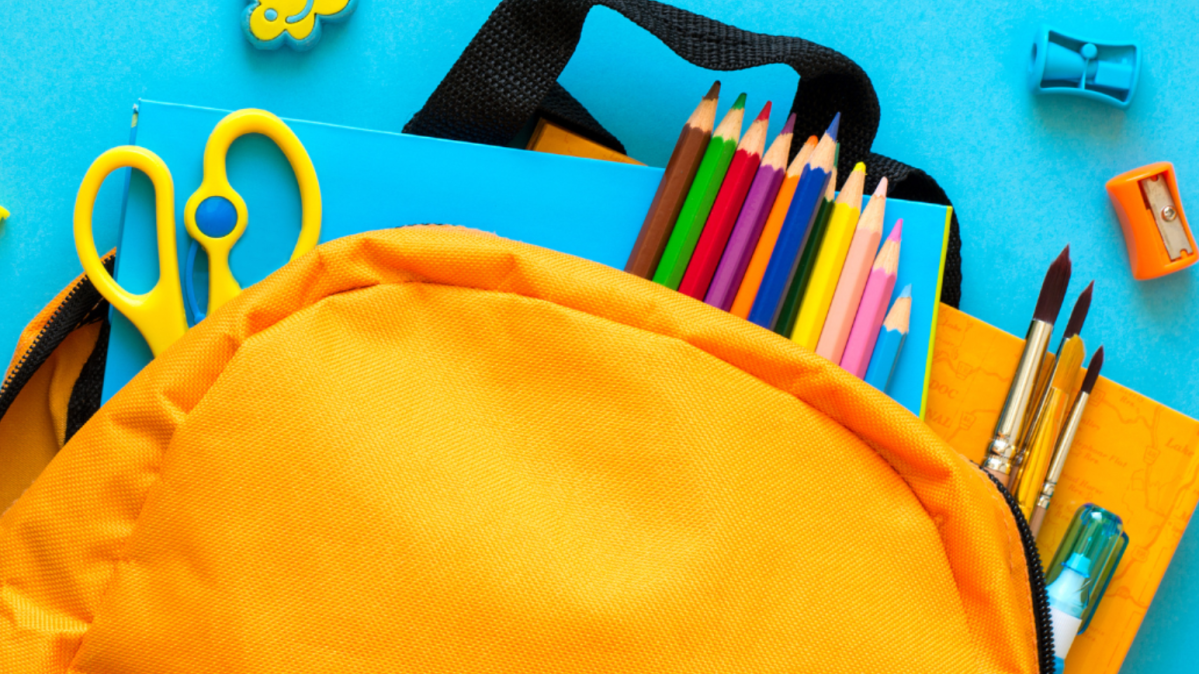 A yellow backpack with school supplies pouring out of it on a light blue background.