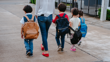Walking to school. Children walking to school with a parent.