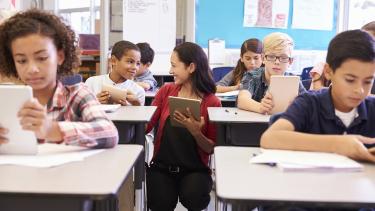 Teacher working with students at their desks.