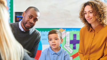 Parents and a student meeting a teacher.