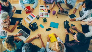 Adults sitting around a table at a meeting.