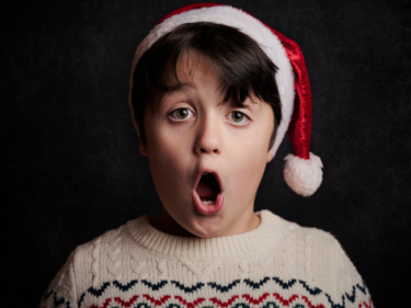A student in a Santa hat singing.