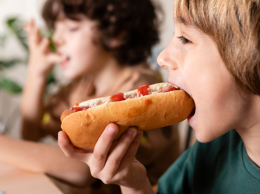 Boy eating hotdog.