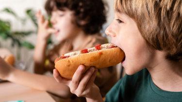 Hot Lunch Day - Hot dogs & Krispy Kreme Doughnuts Boy eating hotdog.