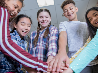 Students reaching in for a team cheer.