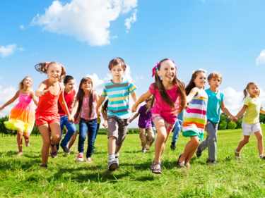 Children running outside on a sunny day.