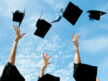 Graduation caps being thrown into the air.