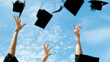 Graduation caps being thrown into the air.