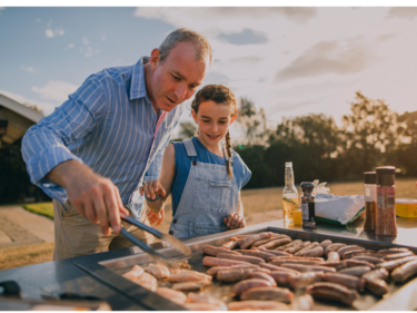 Father and daughter BBQing on a sunny day.