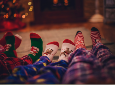 The legs in family members in pjs with Christmas socks.