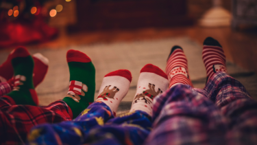 The legs in family members in pjs with Christmas socks.