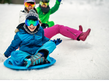 Kids sledding down a snowy hill.