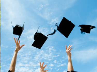 Graduation caps being thrown into the air.