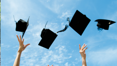 Graduation caps being thrown into the air.