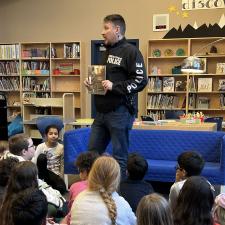 Constable Neil Cole sharing a book with students.