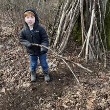 Student building a structure out of sticks.