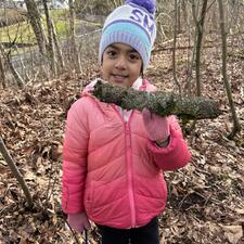 Student showing moss on some bark.
