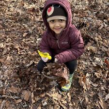 Student playing in the leaves.