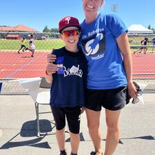 Teacher with a student outside at a track.