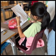 A student cutting out words from a word list.