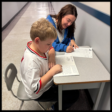 A teacher assessing a students' reading.