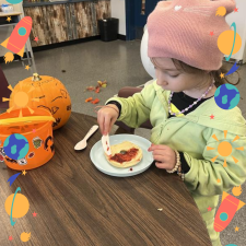 A student spreading jam onto a bagel.