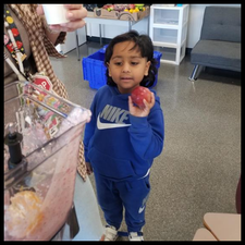 A student holding an apple.